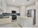 Bright kitchen with white cabinets, stainless steel appliances, and blue tile backsplash at 3842 Beacon Ridge Way, Clermont, FL 34711