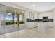 Modern kitchen with white cabinets, mosaic backsplash, island, and access to a screened-in patio at 3842 Beacon Ridge Way, Clermont, FL 34711