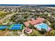 Aerial view showcases community amenities: pool, clubhouse, tennis courts, and lush landscaping at 3948 Serena Ln, Clermont, FL 34711