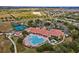 Aerial view showcasing community amenities including pool, tennis courts, clubhouse, and manicured grounds at 3948 Serena Ln, Clermont, FL 34711