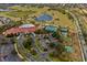 Aerial view of community amenities including a pool, tennis courts, lawn bowling, and a scenic pond at 3948 Serena Ln, Clermont, FL 34711