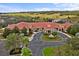 Aerial view of clubhouse with fountain, circular drive and entrance, surrounded by gardens at 3948 Serena Ln, Clermont, FL 34711