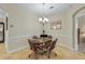 Cozy dining area with a glass table, four chairs, and a chandelier at 3948 Serena Ln, Clermont, FL 34711