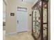 View of the entryway with decorative door and display cabinet on tile floor at 3948 Serena Ln, Clermont, FL 34711