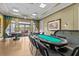 A stylish game room features a poker table, multiple seating areas, and expansive windows overlooking the outdoors at 3948 Serena Ln, Clermont, FL 34711