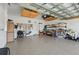 The spacious garage is equipped with storage shelves, mounted tool rack, and a clean epoxy floor at 3948 Serena Ln, Clermont, FL 34711