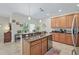Well-equipped kitchen island featuring granite countertops, wooden cabinetry, and stainless steel dishwasher at 3948 Serena Ln, Clermont, FL 34711