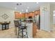 Charming kitchen with wood cabinets, stainless appliances, breakfast bar and stylish pendant lighting at 3948 Serena Ln, Clermont, FL 34711