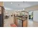 Kitchen island with sink, stainless steel dishwasher, and breakfast bar, with living area in the background at 3948 Serena Ln, Clermont, FL 34711