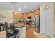 Kitchen view with wood cabinets, stainless appliances, breakfast bar and stylish pendant lighting at 3948 Serena Ln, Clermont, FL 34711