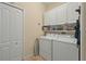 The laundry room features a modern washer and dryer set, complemented by overhead cabinets and closet space at 3948 Serena Ln, Clermont, FL 34711
