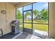 The screened patio includes a barbecue grill and scenic views of the lush green lawn and palm trees at 3948 Serena Ln, Clermont, FL 34711