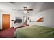Cozy bedroom with a green quilted bedspread, a TV on a dresser, and access to a loft area at 41513 Aspen St, Eustis, FL 32736