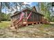 Cozy cabin with a spacious screened-in porch, complete with wooden stairs and decorative lattice at 41513 Aspen St, Eustis, FL 32736