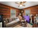 Living room featuring knotty pine walls, neutral sofa and rocking chair at 41513 Aspen St, Eustis, FL 32736