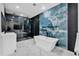 Bright bathroom featuring modern soaking tub, blue accent wall and glass enclosed shower at 42191 Cashew St, Eustis, FL 32736