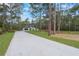 Long driveway leading to a well-manicured home surrounded by lush greenery and tall trees at 42191 Cashew St, Eustis, FL 32736