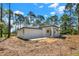Rear exterior of newly built home with fresh grading and a wooded backdrop at 42191 Cashew St, Eustis, FL 32736