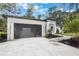 Modern home featuring a sleek, dark gray garage door and contemporary landscaping at 42191 Cashew St, Eustis, FL 32736