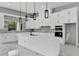 Bright kitchen features white cabinets, a large island, modern pendant lighting, and high-end appliances at 42191 Cashew St, Eustis, FL 32736
