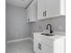 Modern laundry room featuring white cabinets and black hardware at 42191 Cashew St, Eustis, FL 32736