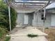 View of a home's exterior with a pergola and damaged stucco at 447 E Desoto St, Clermont, FL 34711