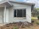 Exterior of a small home with a cracked foundation and an overgrown landscape at 447 E Desoto St, Clermont, FL 34711