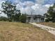 One-story home featuring a concrete walkway and trees in the front yard at 447 E Desoto St, Clermont, FL 34711