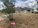 Single-story home with a concrete block exterior and mature trees in the front yard at 447 E Desoto St, Clermont, FL 34711