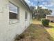 Side view of property with peeling paint and yard debris at 447 E Desoto St, Clermont, FL 34711