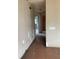Hallway with peeling paint, damaged walls, and a glimpse into connecting rooms at 447 E Desoto St, Clermont, FL 34711