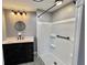 Bathroom with updated black vanity, a round mirror, and shower at 519 Hawthorne Blvd, Leesburg, FL 34748