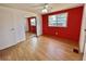 Bright bedroom with red wall, closet with mirrors and a ceiling fan at 519 Hawthorne Blvd, Leesburg, FL 34748