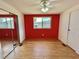 Bedroom with closet doors with mirrors, red wall, and window at 519 Hawthorne Blvd, Leesburg, FL 34748