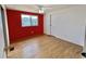 Bedroom featuring a window, closet, and red accent wall at 519 Hawthorne Blvd, Leesburg, FL 34748