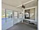Enclosed porch area featuring a ceiling fan, sliding glass door, and tiled flooring at 519 Hawthorne Blvd, Leesburg, FL 34748
