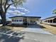 Attractive home exterior features a long driveway leading to a covered carport at 519 Hawthorne Blvd, Leesburg, FL 34748