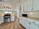 White kitchen cabinets, stainless steel range, and an open floor plan at 519 Hawthorne Blvd, Leesburg, FL 34748