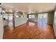 Spacious living area featuring wood flooring, a ceiling fan, and easy access to the kitchen at 519 Hawthorne Blvd, Leesburg, FL 34748