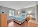 Bright bedroom featuring hardwood floors, a plush bed with blue comforter, and matching wooden dressers at 529 Valencia Pl, Lady Lake, FL 32159