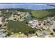 Overhead view of home on a waterfront lot with mature trees and manicured lawn at 5339 Kings Ct, Fruitland Park, FL 34731