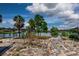 Spacious backyard featuring a waterfront view, mature trees, and a quaint pergola for enjoying outdoor living at 5339 Kings Ct, Fruitland Park, FL 34731