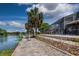 Waterfront home boasts a screened-in lanai, concrete path, and landscaping along the water's edge at 5339 Kings Ct, Fruitland Park, FL 34731