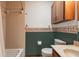 Bathroom with tiled shower/bath, cabinet storage, and floral wallpaper border at 5339 Kings Ct, Fruitland Park, FL 34731