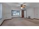 Bright bedroom with neutral carpet, a ceiling fan and a large window at 5339 Kings Ct, Fruitland Park, FL 34731