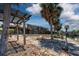 Exterior view of the waterfront property featuring an outdoor pergola and lush landscaping at 5339 Kings Ct, Fruitland Park, FL 34731
