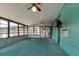 Enclosed porch with a calming teal interior that features a ceiling fan and several windows for natural lighting at 5339 Kings Ct, Fruitland Park, FL 34731