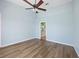 Bedroom with hardwood floors, ceiling fan and access to a bathroom at 5492 Compass Pt, Oxford, FL 34484
