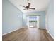 Bedroom with wood floors, ceiling fan and sliding glass doors to a balcony overlooking a pond at 5492 Compass Pt, Oxford, FL 34484