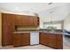 Kitchen features wooden cabinets, granite countertops, dishwasher and eat-in bar at 5492 Compass Pt, Oxford, FL 34484